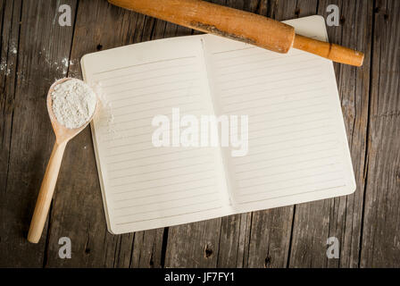 Baking background. Tools and ingredients for baking on the old rustic wooden table. Book notepad for recipes. Top view copy space Stock Photo