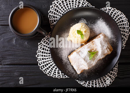 Apple strudel with vanilla ice cream on a plate and coffee with milk close-up. horizontal view from above Stock Photo