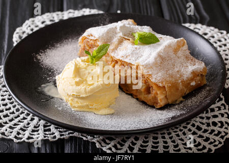 Apple strudel with vanilla ice cream on a plate close-up. Horizontal Stock Photo