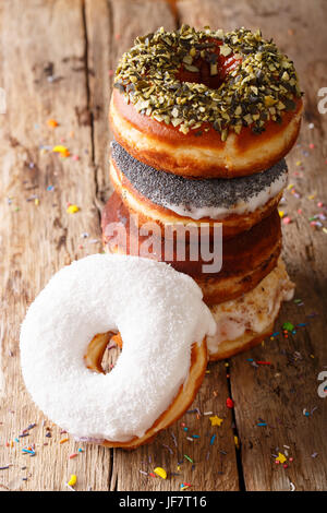stack of glazed multicolored donuts close-up on a table. vertical Stock Photo