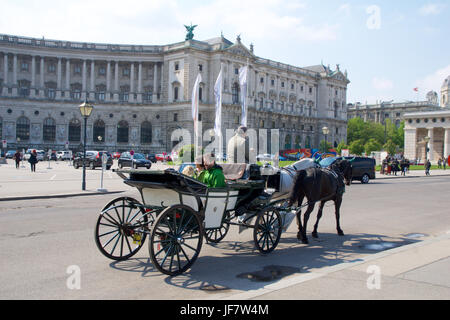 VIENNA, AUSTRIA - APR 29th, 2017: Famous horse-driven carriage at Hofburg Palace in Vienna. It was the Habsburgs' principal winter residence, currently serves as the residence of the President of Austria Stock Photo