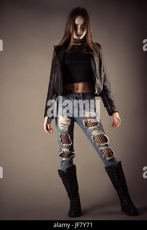 fashionable teenager girl in leather jacket and torn jeans Stock Photo