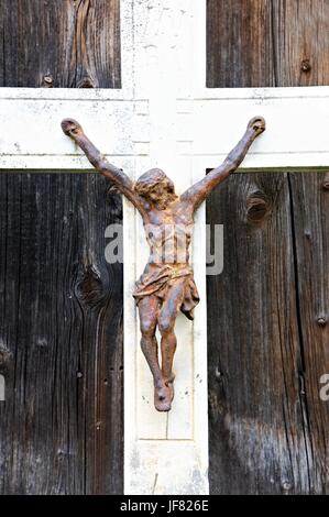 Stone cross with rusty Christ Stock Photo