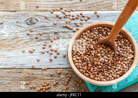 Wooden spoon in a bowl of lentils. Stock Photo