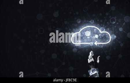 Mans hand pointing to light cloud on dark background Stock Photo