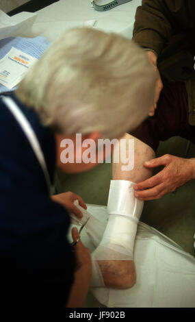 District nurse on a home visit dressing a persons leg ulcers Stock Photo