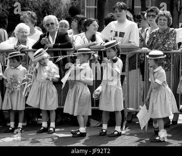 Tired of waiting! School girls wearing boaters looking bored as they wait for a royal visit. Stock Photo