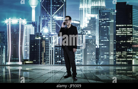 Happy smiling businessman using  smartphone , blurred morden city skyline . Stock Photo