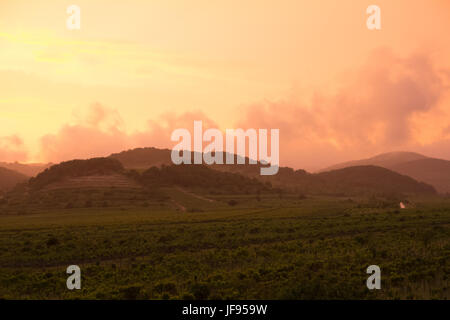 orange dramatic sunset over hills Stock Photo