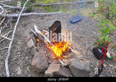 Cooking soup from a pike at the stake. The fire, pots and accessories. Stock Photo