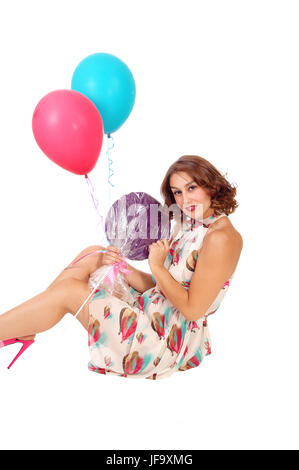 Woman sitting on floor with balloons. Stock Photo