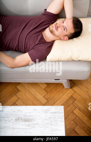 Young man lying on the sofa Stock Photo