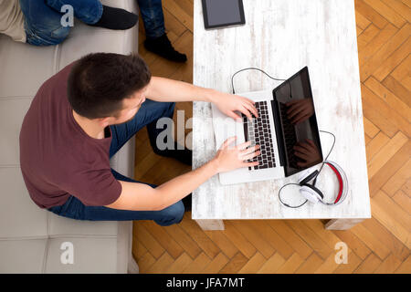 Young man typing on his laptop Stock Photo