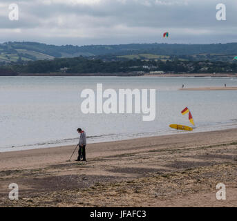 Exmouth, Devon, UK. 30th June 2017. A man searches for treasure with a metal detector on the beach at Exmouth on a cloudy overcast day. Credit: Photo Central/Alamy Live News Stock Photo