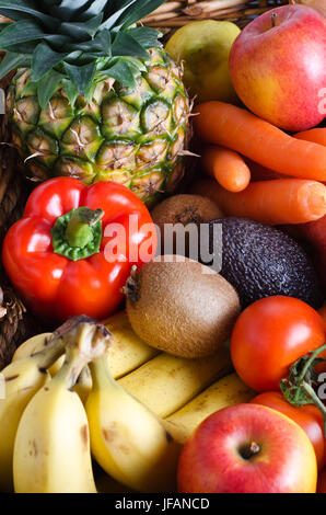Overhead shot of a selection of fresh fruit and vegetables in a wicker basket.  Portrait orientation. Stock Photo