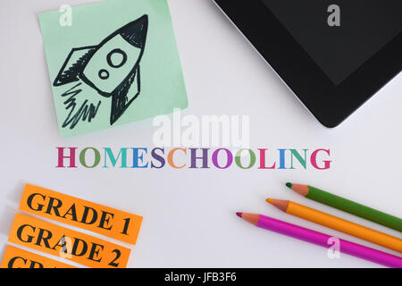 Homeschooling. Digital tablet, pencils and paper notes with a rocket on it. Homeschooling concept image. The education of children at home by their pa Stock Photo