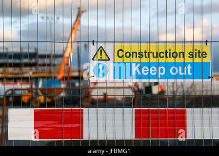 Construction site warning signs in yellow and blue instructing people to Keep Out