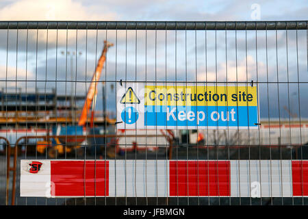 Construction site warning signs in yellow and blue instructing people to Keep Out