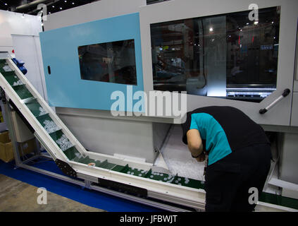 Worker operating bottle cap making machine Stock Photo