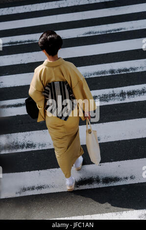 Young woman wearimg a kimono, on a pedestrian crossing. from overhead Stock Photo