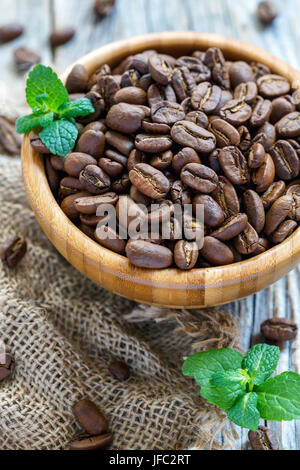 Coffee beans and mint in round wooden bowl. Stock Photo