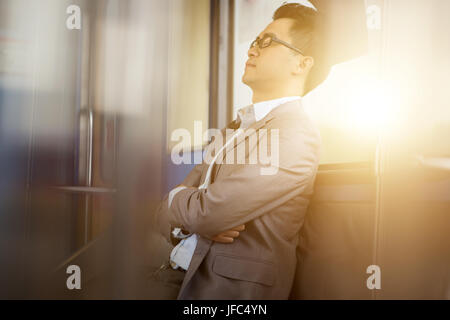 Asian businessman taking a nap inside train while travelling to work. Stock Photo