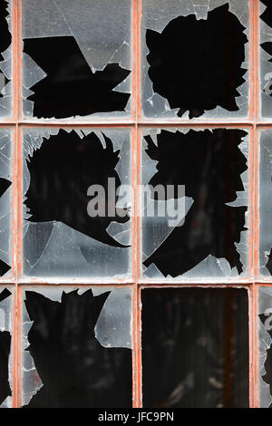 Damage window with broken glass and dark background. Vertical Stock Photo