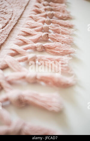 Tassels of a textile on a white background. Pink towel. Stock Photo