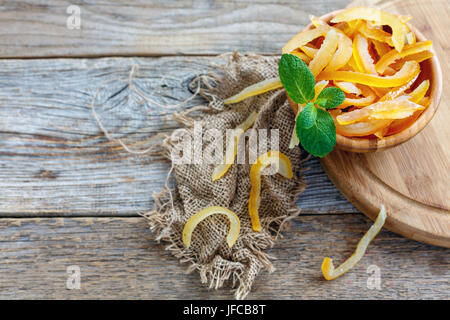 Candied orange peel and mint in a wooden bowl. Stock Photo