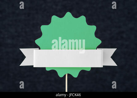 Green shaped circle cut from cardboard on a wooden stick. Template for round paper badge, label, sign, plague or design element. Stock Photo