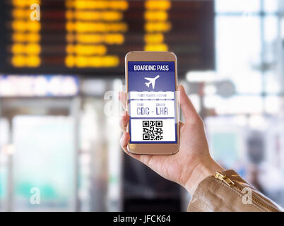 Boarding pass in mobile phone. Woman holding smartphone in airport with modern ticket on screen. Easy and fast access to aeroplane. Stock Photo