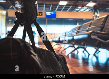 Terrorist in airport planning a bomb attack. Terrorism and security threat concept. Suspicious dangerous man in the shadows with black bag. Stock Photo