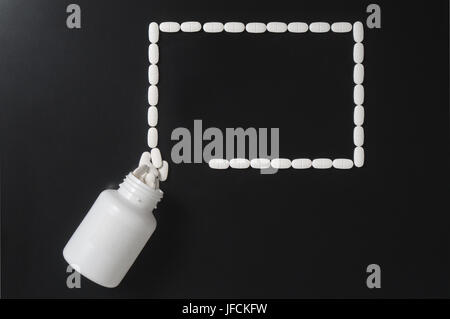Medical presentation background with a lot a free empty copy space for your text. Pills spilling out from bottle and forming a rectangle. Stock Photo