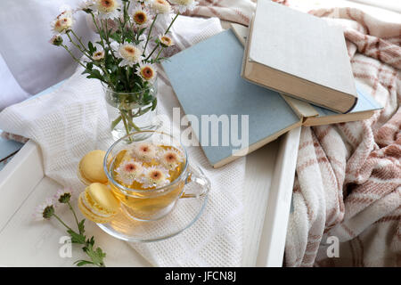 Cup of tea and books in tray on the table Stock Photo