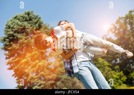 Dream comes true. Creative artistic dreamy kid wearing a superhero costume and playing with his dad who trying entertaining him Stock Photo