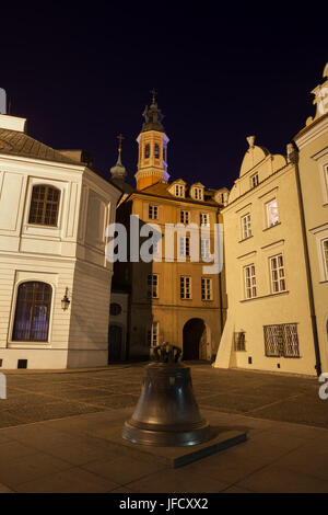 City of Warsaw, Poland, 17th century bronze bell and houses at small square on Kanonia street in Old Town at night Stock Photo