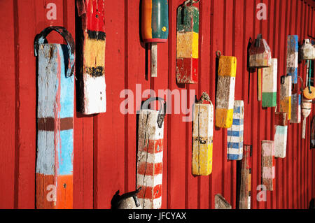 Buoys on a red wall in New England Stock Photo