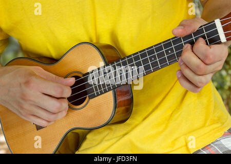 Man's hands playing ukulele Stock Photo
