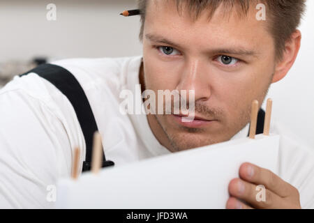 Man putting together self assembly furniture in new home close up. DIY, home and moving concept Stock Photo