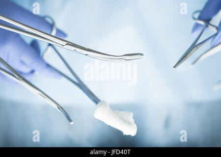 Close-up of doctor's hands holding surgical clamps. Medical background Stock Photo