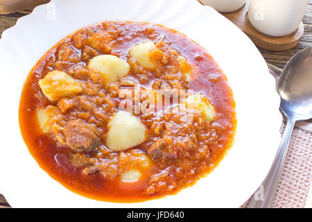 Hungarian goulash soup in plate with spoon Stock Photo