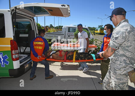 Members of the provincial Disaster Risk Reduction Management Office transport a volunteer with simulated chest injuries into an ambulance during a mass casualty response exercise at Bogo City Hall, Northern Cebu Province, Philippines, June 25, 2017. As part of Pacific Angel 2017, local first responders worked together with U.S. and Philippine forces to share and teach best practices in public health, mass casualty response and other relevant topics. (U.S. Air Force photo/Tech. Sgt. Jeff Andrejcik) Stock Photo