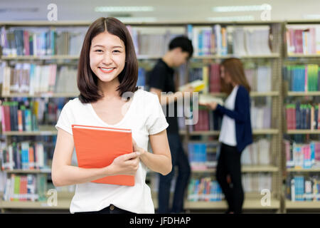 Group of Asian students studying together in library at university. University students. Stock Photo