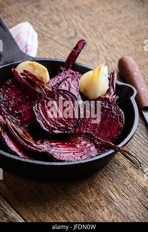 Roasted beetroots in cast iron skillet on wooden rustic table Stock Photo