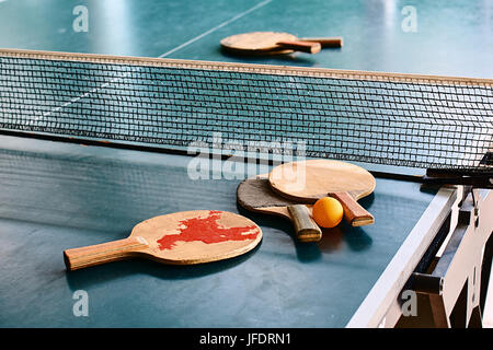 Old used table tennis rackets on the game table Stock Photo