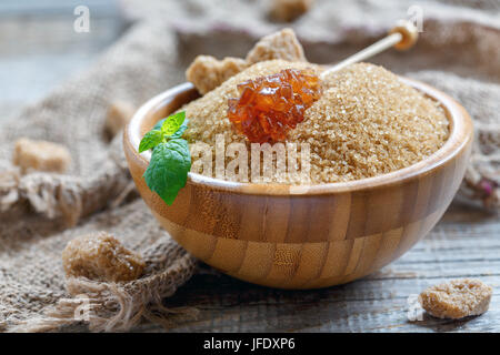 Brown sugar in a wooden bowl close up. Stock Photo