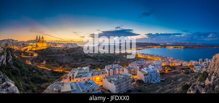 Il-Mellieha, Malta - Beautiful panoramic skyline view of Mellieha town at blue hour with Paris Church and Mellieha beach and Gozo at background with b Stock Photo