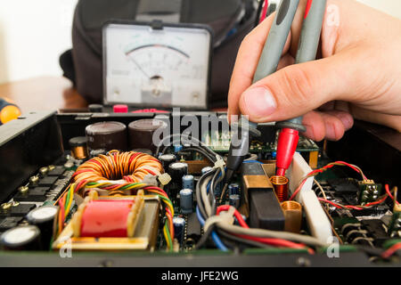 Tech tests electronic equipment in service center Stock Photo