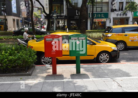 Taxi waits behind two traditional mail boxes here in Taipei, Taiwan. Old culture mixes with new. Stock Photo