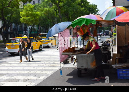 A woman is making fried donuts and other types of bread for people to eat. This is in front of the hospital, so she was getting ready for lunch. Stock Photo